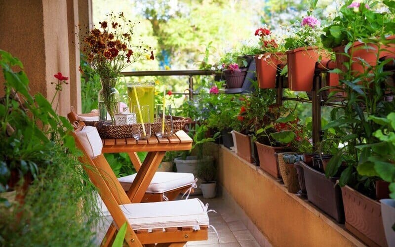 Beautiful balcony with small table, chair and flowers.